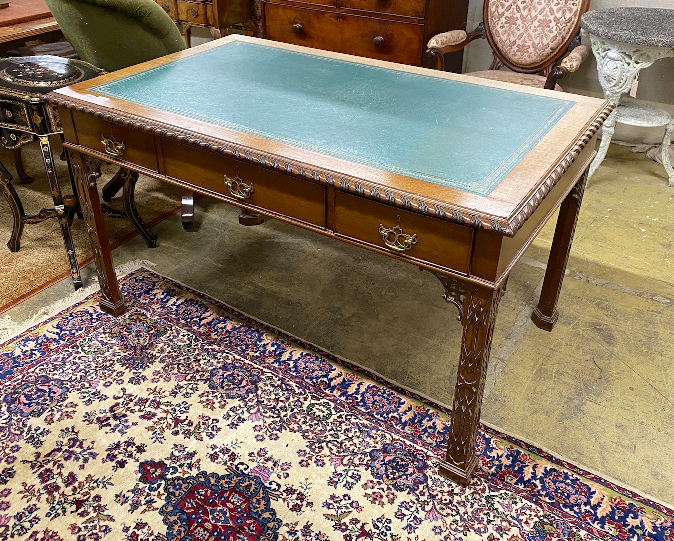 An early 20th century Chippendale revival mahogany partner's writing table, length 139cm, depth 83cm, height 78cm (one side severely sun-faded)